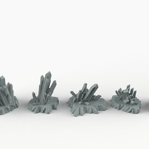 May include: Five different sizes of gray crystal formations, resembling rock formations, on a white background.  The crystals are arranged in a row from largest to smallest.