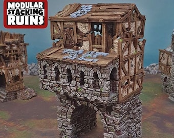 Puede incluir: Un modelo de ruina apilable modular impreso en 3D, hecho de piedra y madera, con un aspecto desgastado y envejecido. El modelo presenta una torre con una puerta arqueada y un segundo nivel con un techo de madera. El modelo es parte de un conjunto de ruinas apilables modulares.