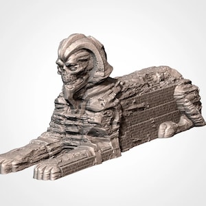 May include: A weathered, gray stone sculpture of a sphinx with a skull-like face. The sculpture is broken and crumbling, with visible cracks and missing pieces.