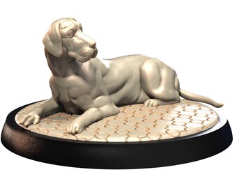 May include: A light gray dog statue in a reclining pose, resting on a patterned, circular base. The base is set on a black, textured, round platform. The dog's features are detailed, with a focused gaze.