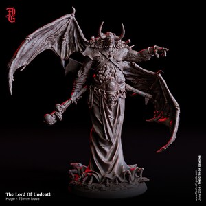 以下が含まれることがあります： 75mm のベースの上に立っている悪魔の王のミニチュアフィギュア。悪魔は、骨格と肉体、角、翼を持つ姿で描かれている。フィギュアは濃いグレーで塗装されている。