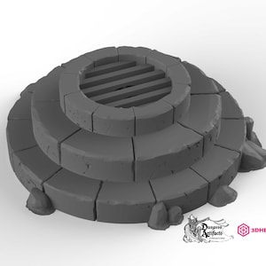 May include: A three-tiered stone well with a metal grate covering the opening. The well is made of gray stone and has a rough, textured surface. The well is surrounded by small rocks.