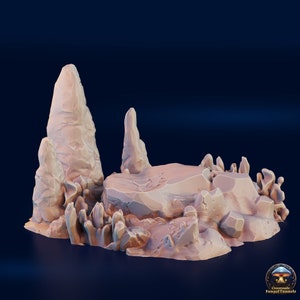 May include: A 3D printed miniature terrain piece featuring a rocky outcropping with tall, thin rock formations. The piece is painted in a light brown color and is designed for use in tabletop games.