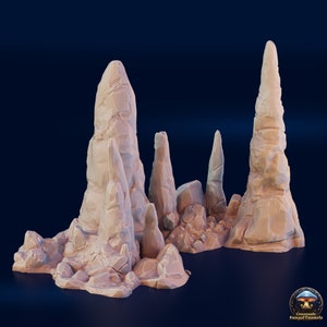 May include: A set of 3D printed, beige-colored rock formations, resembling tall, thin, jagged spires. The formations are arranged in a cluster, with some smaller rocks scattered around the base.