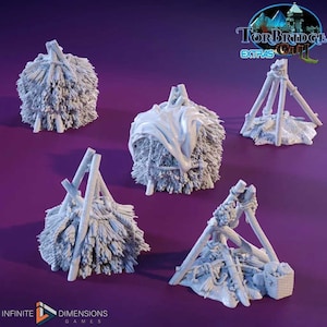 May include: Four miniature models of hay bales, some with wooden supports, for use in tabletop games or dioramas. The models are painted in a light gray color.