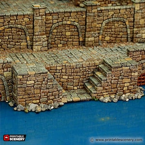 Può includere: Un muro di pietra con una serie di gradini che conducono a una superficie blu. Il muro è fatto di pietre ruvide di colore marrone e ha alcuni archi. I gradini sono fatti della stessa pietra e hanno alcuni gradini. La superficie blu è liscia e sembra essere acqua.