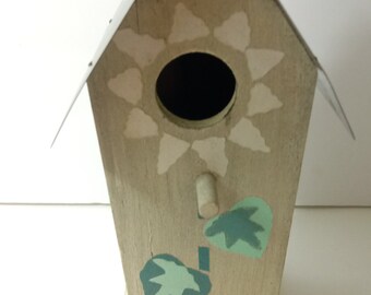 Casa de pájaros rústica de madera con techo de hojalata y calcomanías florales