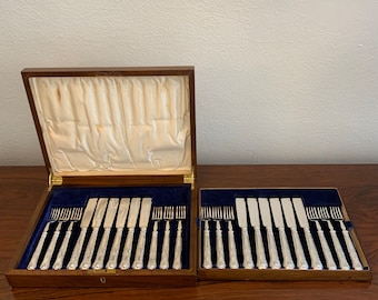 May include: A set of silver cutlery in a wooden box. The cutlery includes knives and forks. The box is lined with blue velvet.
