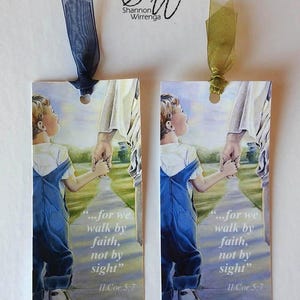 May include: Two bookmarks with a watercolor illustration of a child holding hands with a man walking down a path. The text on the bookmarks reads "...for we walk by faith, not by sight" II Cor 5:7.