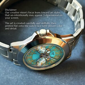 May include: A stainless steel wristwatch with a teal face featuring a butterfly design and Roman numerals. The watch has a silver band and the text "Disclaimer" and other text is visible.