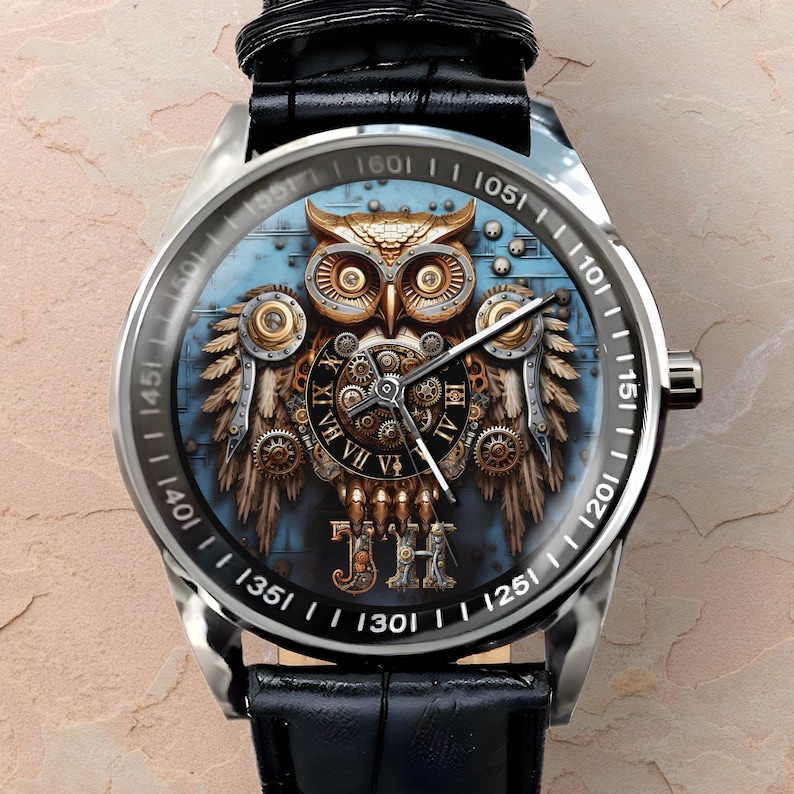 K&ouml;nnte beinhalten: Silberne Armbanduhr mit schwarzem Lederarmband. Das Zifferblatt zeigt ein detailliertes Steampunk-Eulen-Design mit Zahnr&auml;dern und blauem Hintergrund. Die L&uuml;nette hat schwarze Markierungen. Die Uhr hat ein silbernes Geh&auml;use.