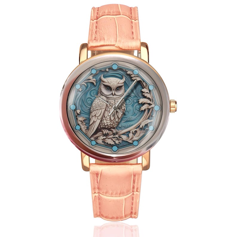 May include: A gold-coloured wristwatch with a pale pink leather strap. The watch face displays a detailed owl design in white and blue, set against a light blue background. The watch has a round face and a pale pink strap.