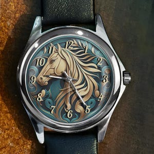 Könnte beinhalten: Eine silberne Armbanduhr mit einem schwarzen Lederarmband. Das Zifferblatt zeigt eine detaillierte Illustration eines Pferdekopfes in Gold und Türkis, mit einer klassischen Ziffernanzeige. Die Zeiger der Uhr sind silberfarben.