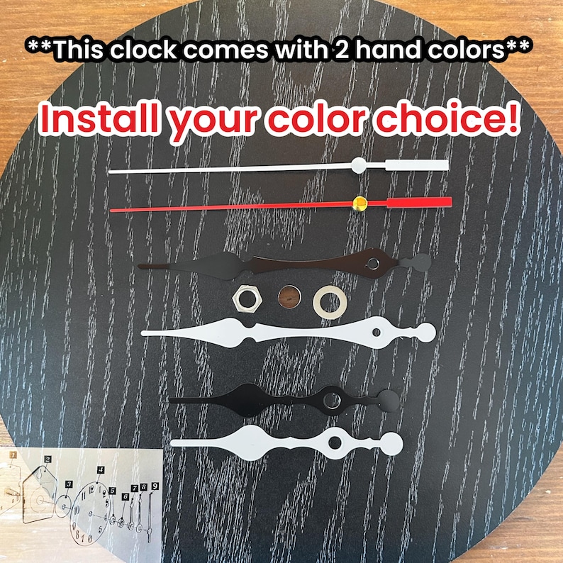 May include: Clock hands in white, red, and black, with a gold-colored center piece. The image includes the text "Install your color choice!" and "This clock comes with 2 hand colors."
