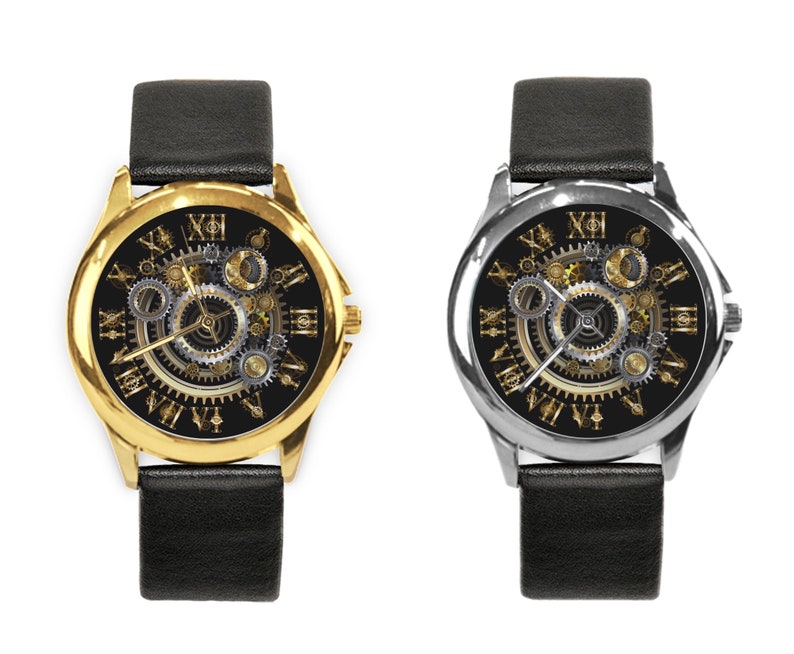 K&ouml;nnte beinhalten: Zwei Armbanduhren mit schwarzen Lederb&auml;ndern. Das Zifferblatt der Uhr links hat ein goldenes Geh&auml;use und das Zifferblatt der Uhr rechts ein silbernes Geh&auml;use. Beide Zifferbl&auml;tter haben einen schwarzen Hintergrund mit goldenen r&ouml;mischen Ziffern f&uuml;r die Stunden und ein detailliertes, kompliziertes, goldfarbenes Zahnrad-Design.