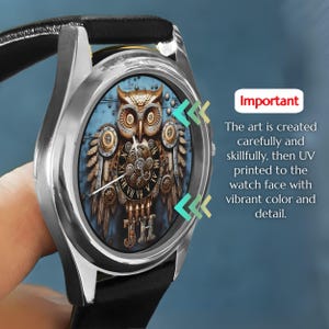 K&ouml;nnte beinhalten: Eine silberne Armbanduhr mit schwarzem Lederarmband. Das Zifferblatt zeigt ein detailliertes Eulen-Design mit Zahnr&auml;dern und einem r&ouml;mischen Zifferblatt. Der Text "Wichtig" und eine Beschreibung des Kunstprozesses sind ebenfalls sichtbar.