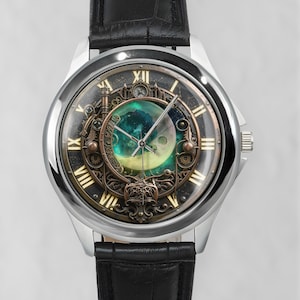 Könnte beinhalten: Eine Armbanduhr mit schwarzem Lederarmband und silbernem Gehäuse. Das Zifferblatt zeigt goldene römische Ziffern, eine zentrale kreisförmige Anzeige mit einem Halbmond vor einem türkisfarbenen Nebelhintergrund und bronzefarbene Zahnrad-Details.