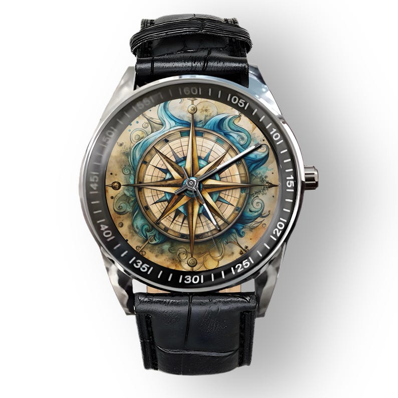 May include: A silver wristwatch with a black leather band. The watch face features a compass rose design in shades of gold, blue, and beige, with a black bezel and white numerals. The watch band is approximately 9 inches long.