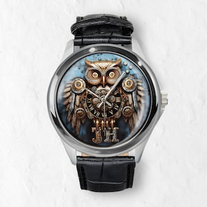 K&ouml;nnte beinhalten: Silberne Armbanduhr mit schwarzem Lederarmband. Das Zifferblatt zeigt ein detailliertes Steampunk-Eulen-Design mit Zahnr&auml;dern, r&ouml;mischen Ziffern und den Initialen "JH". Die Eule ist in Gold-, Bronze- und Braunt&ouml;nen vor blauem Hintergrund.