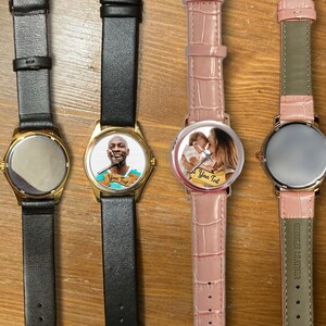 May include: Four wristwatches with different colored bands and face designs. The watches have gold-colored cases and are displayed on a wooden surface. One watch has a photo of a person on the face, another has a photo of a mother and child, and the other two have blank faces.