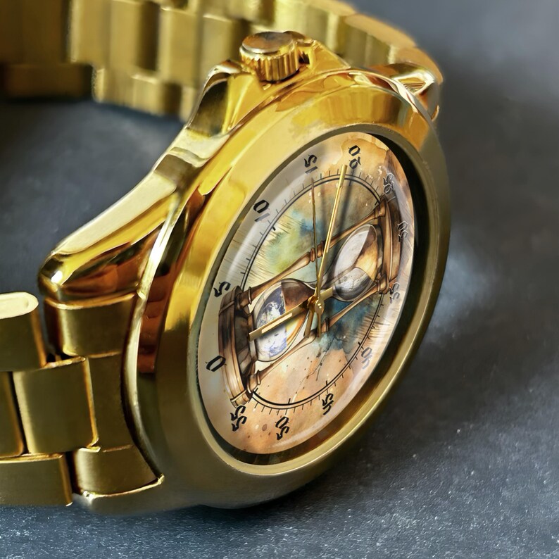 K&ouml;nnte beinhalten: Goldfarbene Armbanduhr mit detailliertem Zifferblatt mit einem Sanduhr-Design. Die Uhr hat ein goldenes Armband und ein rundes Zifferblatt mit Stundenmarkierungen. Die Uhr ist aus Metall und hat eine gl&auml;nzende Oberfl&auml;che.