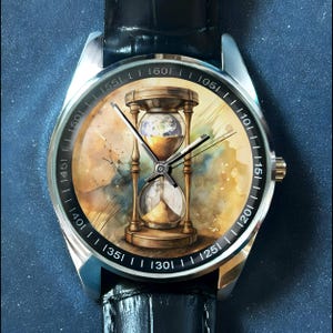 K&ouml;nnte beinhalten: Eine silberne Armbanduhr mit schwarzem Lederarmband. Das Zifferblatt zeigt ein Aquarellgem&auml;lde einer Sanduhr mit der Erde im Inneren. Der Hintergrund hat ein gelbes und blaues Aquarelldesign. Die Uhr hat schwarze Zeiger und wei&szlig;e Zahlen.