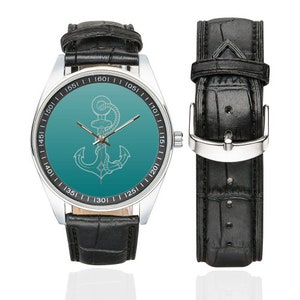 Puede incluir: Un reloj de pulsera plateado con una correa de cuero negro. La esfera del reloj tiene un fondo degradado turquesa con un dise&ntilde;o de ancla blanca. Los n&uacute;meros en la esfera del reloj son negros.