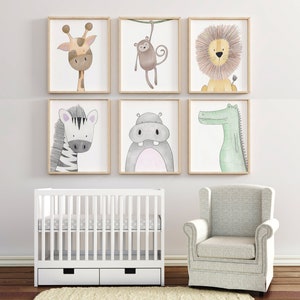 May include: Six framed watercolour animal prints, including a giraffe, monkey, lion, zebra, hippo, and crocodile. The artwork is displayed above a white cot and a grey armchair, creating a nursery theme.