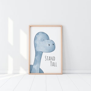 May include: A framed print with a blue watercolor illustration of a dinosaur's head and the text "STAND TALL".