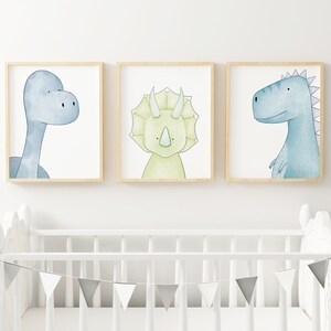 May include: Three framed watercolor illustrations of dinosaurs. The first shows a blue dinosaur with a long neck, the second shows a green dinosaur with three horns, and the third shows a blue dinosaur with spikes on its back.