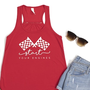 May include: Red racerback tank top with white checkered flags and the text "start your engines".