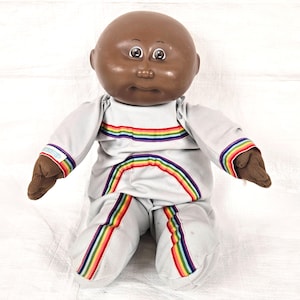 Jaren 80 koolpatch kinderpop met authentieke grijze en regenboogtrui / onsie, vintage jaren 80 kinderspeelgoed tekenfilms tv, bruine ogen kaal zwart