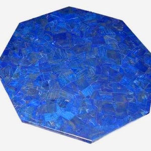 Op de afbeelding: Een achthoekig tafelblad met een mozaïekontwerp. Het oppervlak is diepblauw, samengesteld uit onregelmatig gevormde stukken die een textuur creëren. De randen zijn schoon en gedefinieerd, met een gepolijste afwerking.