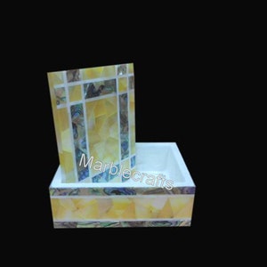 Op de afbeelding: Een decoratieve marmeren doos met een bijpassend rechtopstaand stuk. De doos en de opstaande rand zijn versierd met gele, witte en iriserende mozaïektegels. De tekst "Marblecrafts" is zichtbaar.