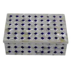 Op de afbeelding: Een rechthoekige doos met deksel, versierd met een mozaïekpatroon van wit parelmoer. Het ontwerp bevat kleine, donkerblauwe ruitvormen, die een geometrisch patroon vormen. De doos staat tegen een effen witte achtergrond.