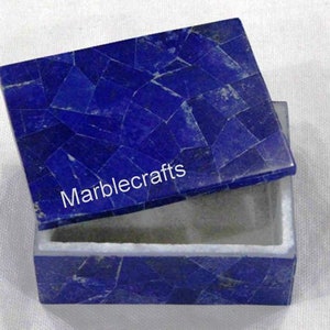 Op de afbeelding: Een rechthoekige doos met een scharnierend deksel, gemaakt van diepblauwe mozaïeksteen. Het deksel staat iets open en toont de binnenkant. De tekst "Marblecrafts" staat op het deksel. Geschikt voor sieraden of kleine aandenkens.