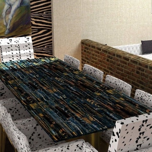 May include: A rectangular dining table with a dark, patterned surface, surrounded by eight chairs with white and black spotted upholstery. The table's surface has a blue, gold, and black design. The chairs have gold legs.