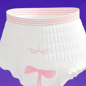 Puede incluir: Ropa interior blanca con un lazo rosa y una superficie texturizada. La ropa interior tiene una cintura elástica rosa con múltiples filas de costuras.