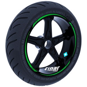 Könnte beinhalten: Ein schwarzer Motorradreifen mit einem grünen Felgenstreifen, auf dem in weißer Schrift "FLUORESCENT RIM STRIPE / JANT SERIDI / FLUORESAN JANT SERIDI / REFLECTIVE RIM STRIPE / REFLEKTİF JANT SERİDİ / Çınar Extreme®" steht. Der Reifen hat außerdem einen grünen Aufkleber mit der Aufschrift "TÜRKİYE'DE ÜRETİLMİŞTİR / MADE IN TURKEY / Çınar Extreme®".