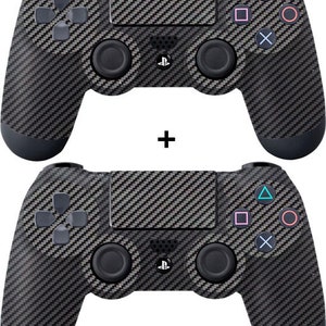 May include: Two black PlayStation 4 controllers with a carbon fiber design. The controllers have a black and gray pattern.