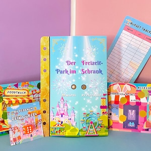 Könnte beinhalten: Ein Set aus bunten, bedruckten Spielplänen aus Papier und einem Budget-Tracker. Das zentrale Element ist eine Mappe mit dem Titel Der Freizeit-Park im Schrank. Weitere Teile sind eine Foodtruck-Szene, eine Einkaufszentrum-Grafik und eine Karte mit Dein Würfel.