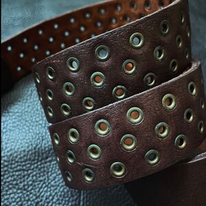 Leather belt with metal eyelets