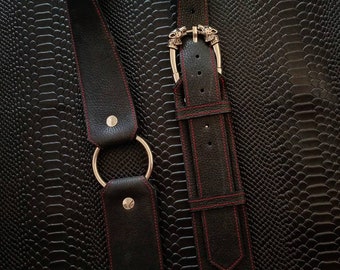 Leather guitar strap with contrasting stitching, ring, and wolf-shaped buckle. Adjustable, handmade.