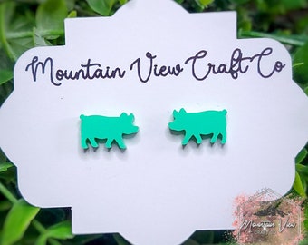 May include: A pair of green pig earrings on a white card with the text "Mountain View Craft Co."