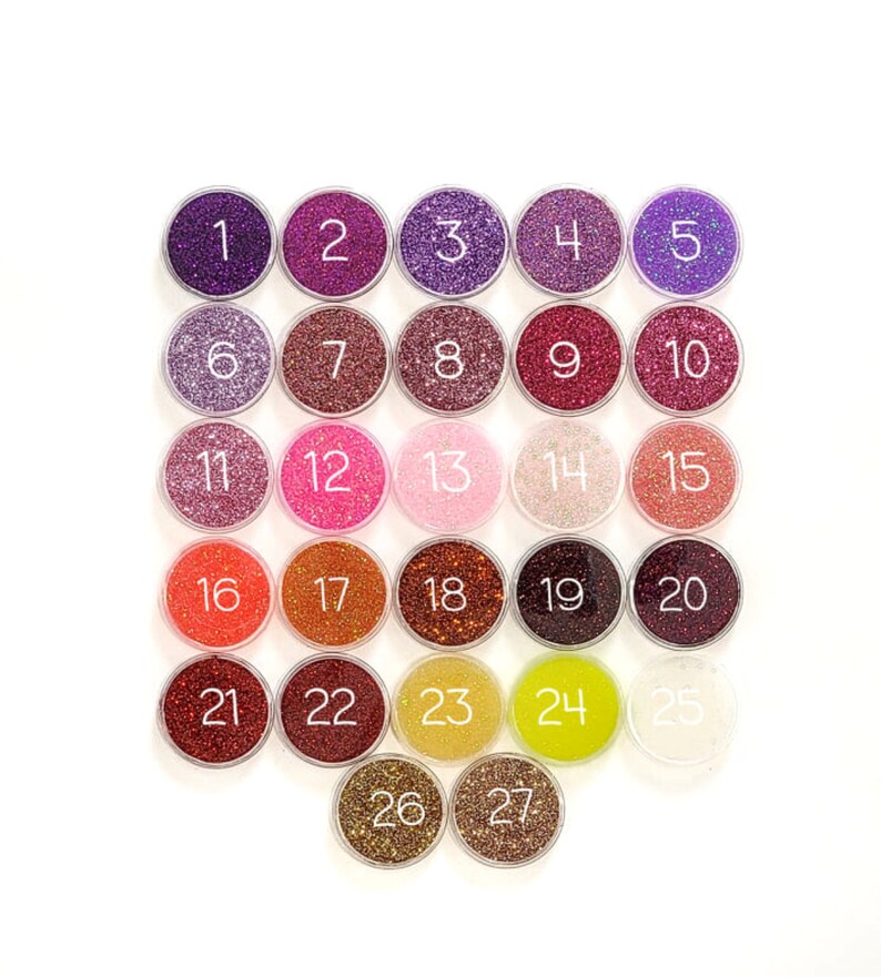May include: Twenty-seven small jars of glitter, each with a number from 1 to 27. The glitter is in various colors, including purple, pink, red, orange, and gold.