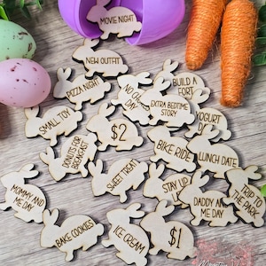May include: Wooden bunny-shaped tokens with various activities written on them, such as "Movie Night", "Pizza Night", "Bake Cookies", "Ice Cream", "Sweet Treat", "Bike Ride", "Lunch Date", "Daddy and Me Day", "Trip to the Park", "Stay Up Late", "Mommy and Me Day", "Donuts for Breakfast", "Small Toy", "New Outfit", "Build a Fort", "Extra Bedtime Story", "Yogurt Day", "No Chores Day", and "£1" and "£2".
