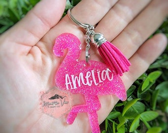 May include: Pink glitter flamingo keychain with a pink tassel and the name Amelia written on it.
