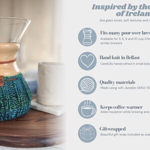 K&ouml;nnte beinhalten: Ein Glas-Kaffeebereiter mit Holzkragen und einem handgestrickten, blau-gr&uuml;nen Garn&uuml;berzug. Der &Uuml;berzug hat ein kleines braunes Lederetikett mit der Aufschrift Red Cellar Designs. Der Text auf der rechten Seite listet Merkmale auf: passt f&uuml;r viele Kaffeebereiter, handgestrickt in Belfast, Qualit&auml;tsmaterialien, h&auml;lt Kaffee warm und als Geschenk verpackt.
