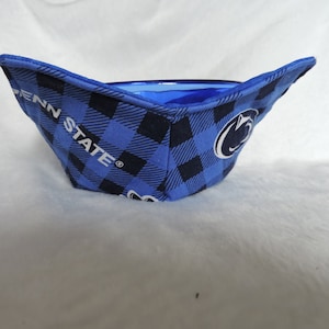 May include: A blue and black plaid bowl with the Penn State Nittany Lion logo and the words "Penn State" in white.