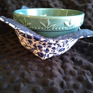 May include: A blue and white floral bowl cozy with a teal ceramic bowl inside.